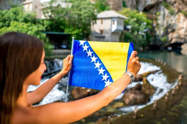 Mujer con bandera bosnia en pueblo Blagaj — Foto de Stock