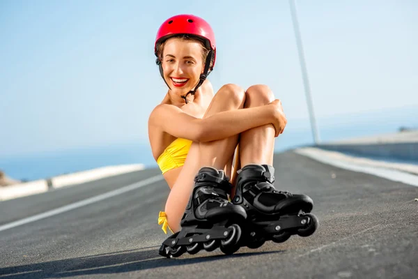 Woman in swimsuit with rollers on the highway — ストック写真