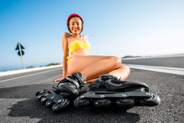 Woman in swimsuit with rollers on the highway — Stock Photo, Image