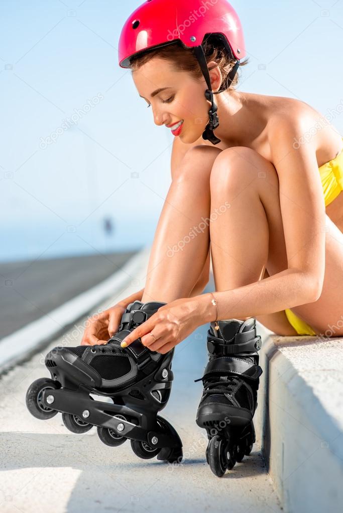 Woman in swimsuit with rollers on the highway