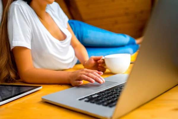 Donna che lavora con il computer portatile sul pavimento in legno — Foto Stock