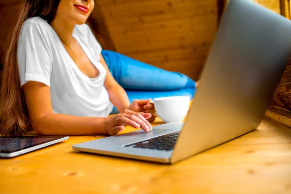 Woman working with laptop on the wooden floor — 스톡 사진