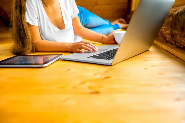 Woman working with laptop on the wooden floor — Stockfoto