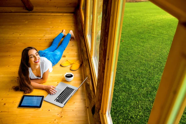 Woman relaxing on the floor in wooden house — Stock Photo, Image