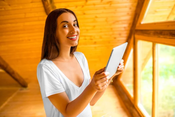 Woman with tablet in the wooden house — Stok fotoğraf