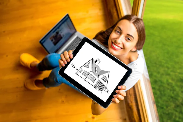 Woman showing digital tablet in the wooden house — Stock fotografie