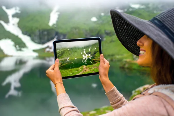 Traveler photographing mountain lake — Stock Photo, Image