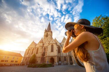 Tourist photographing ghotic cathedral in Romania clipart