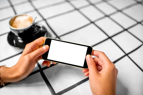 Utilizzando il telefono con caffè in background — Foto Stock