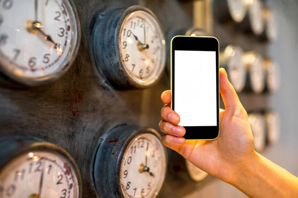 Holding phone with clocks on background — Stock Photo, Image