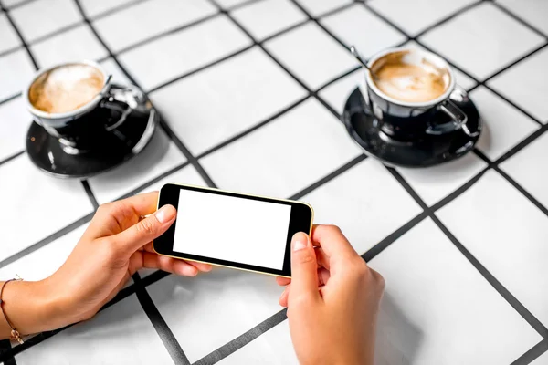 Utilizzando il telefono con caffè in background — Foto Stock