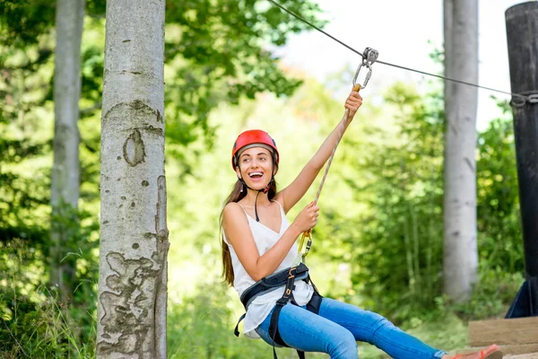 Woman riding on a zip line — Stock Photo, Image