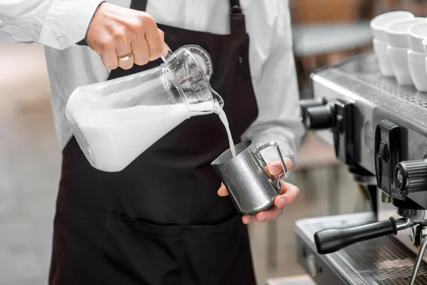 Barista vertiendo leche a la jarra de metal — Foto de Stock