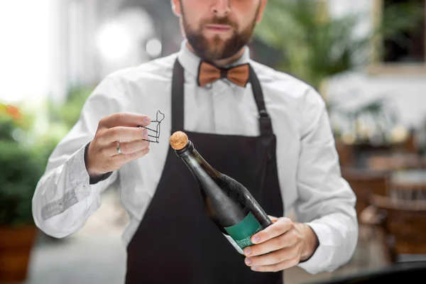 Barman opening bottle with sparkling wine — Stock Photo, Image