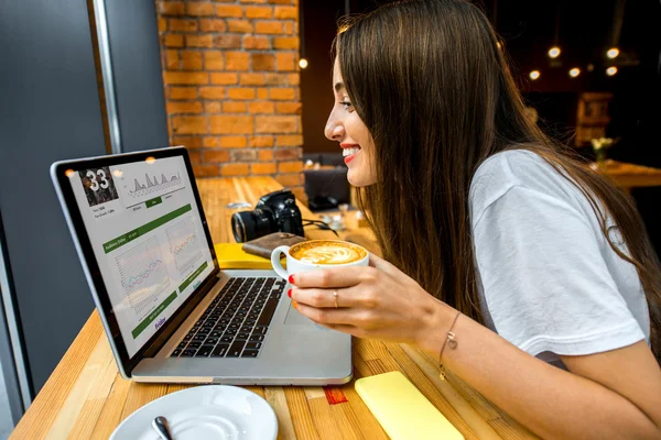 Woman working online with coffee cup — Zdjęcie stockowe