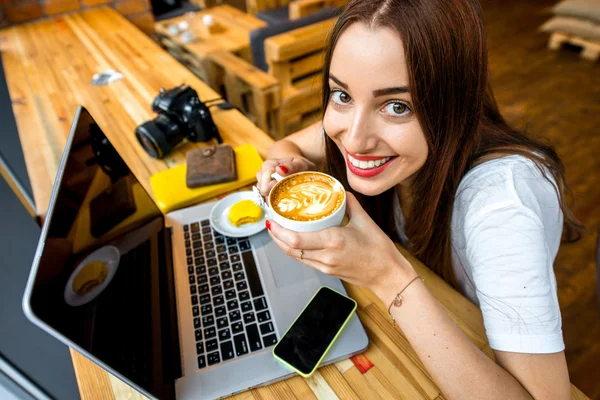 Woman working online with coffee cup — Zdjęcie stockowe