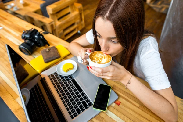 Woman working online with coffee cup — Zdjęcie stockowe