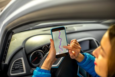 Female driver using smartphone in the car