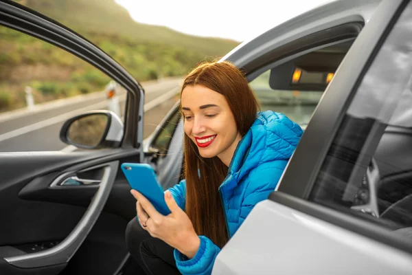 Woman traveling by car on the mountain road — Stock fotografie