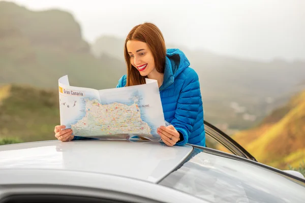 Female traveler with toursit map near the car — Φωτογραφία Αρχείου