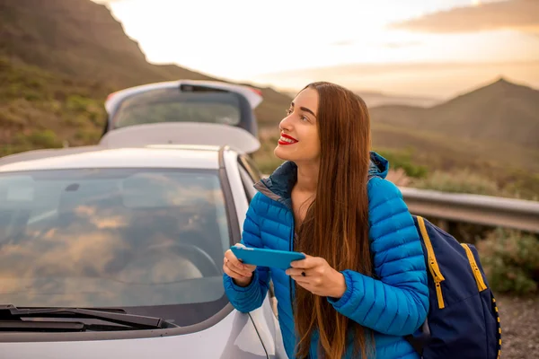 Mujer viajando en coche por el camino de la montaña — Foto de Stock