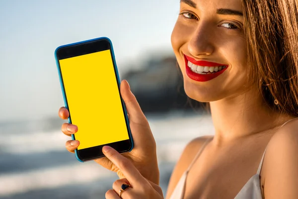 Femme montrant téléphone avec écran blanc — Photo
