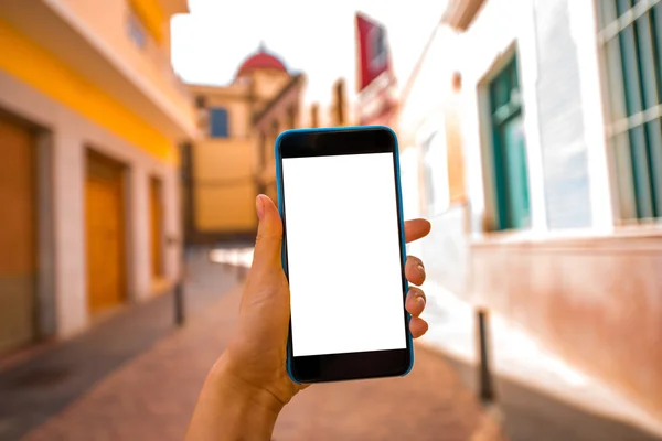 Smartphone con schermo bianco sullo sfondo della vecchia strada cittadina — Foto Stock