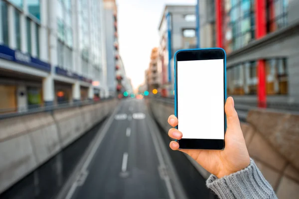 Tenere Smartphone sullo sfondo della città — Foto Stock