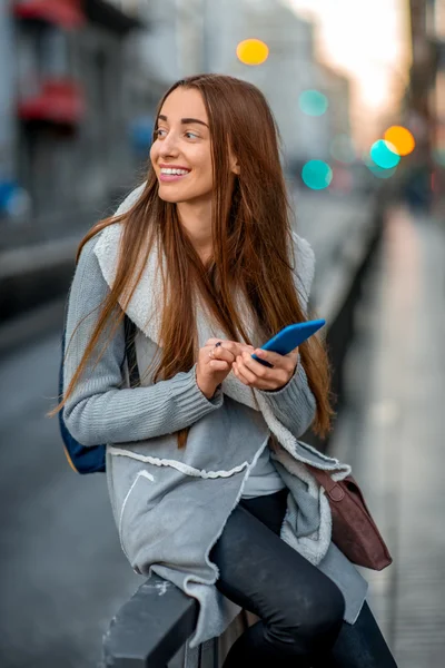 Femme avec téléphone dans la ville — Photo