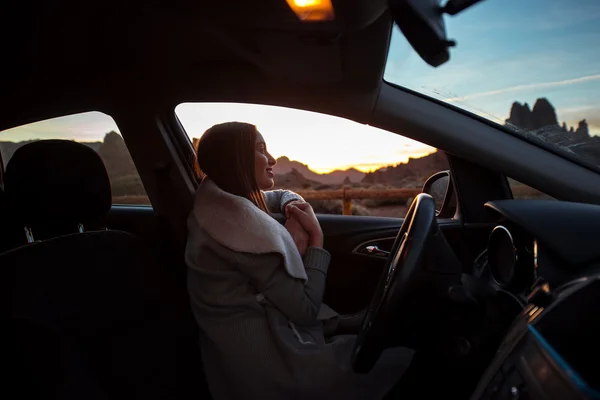 Mujer en el coche disfrutando de la puesta del sol —  Fotos de Stock