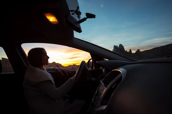 Γυναίκα μέσα στο αυτοκίνητο απολαμβάνουν ηλιοβασίλεμα — Φωτογραφία Αρχείου