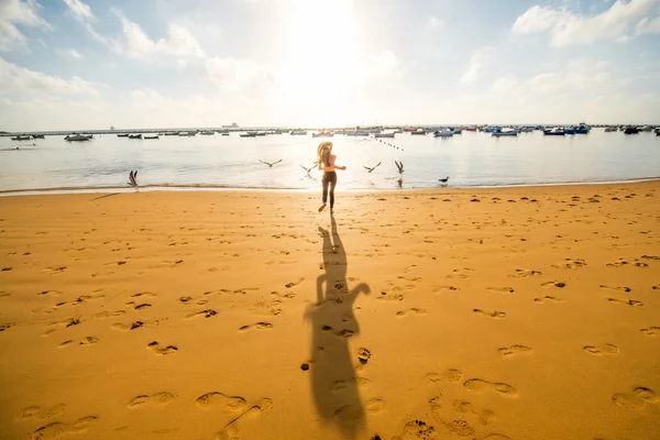 Γυναίκα που τρέχει στην αμμώδη παραλία — Φωτογραφία Αρχείου