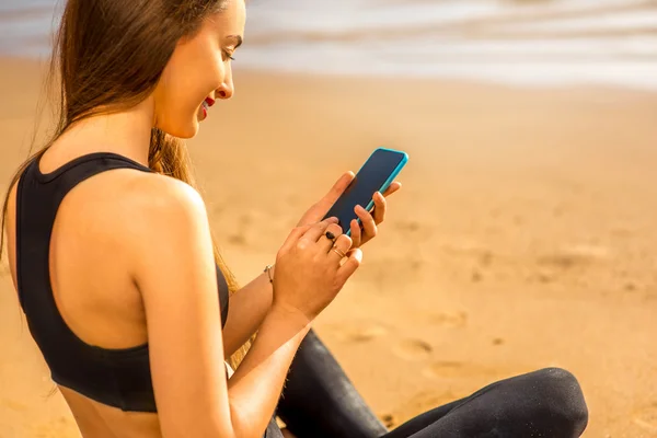 Frau mit Smartphone am Strand — Stockfoto