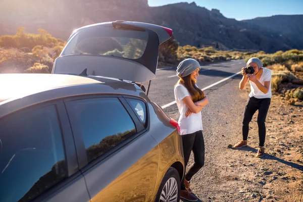 Jóvenes viajeros de pareja divirtiéndose cerca del coche — Foto de Stock