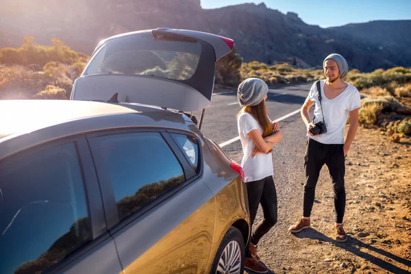 Jovens viajantes casal se divertindo perto do carro — Fotografia de Stock