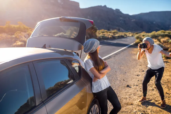 Jóvenes viajeros de pareja divirtiéndose cerca del coche — Foto de Stock