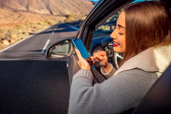 Frau benutzt Smartphone im Auto — Stockfoto
