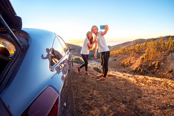 Pareja divirtiéndose cerca del coche — Foto de Stock