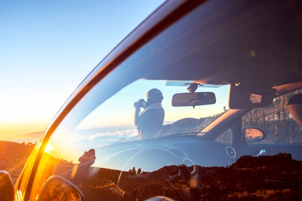 Kvinnan fotografera landskap står nära bilen — Stockfoto