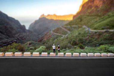 Carefree couple standing on the mountain roadside clipart