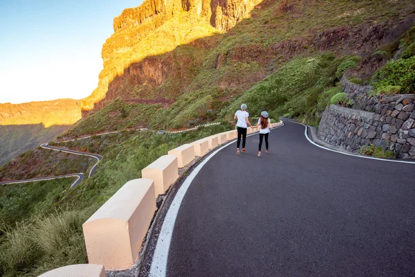 Carefree couple running on the mountain roadside — Stock Photo, Image