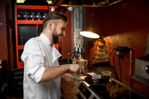 Chef cooking with frying pan — Zdjęcie stockowe