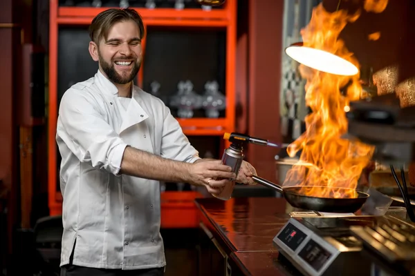 Cuoco pazzo che cucina con grande fuoco sulla padella — Foto Stock