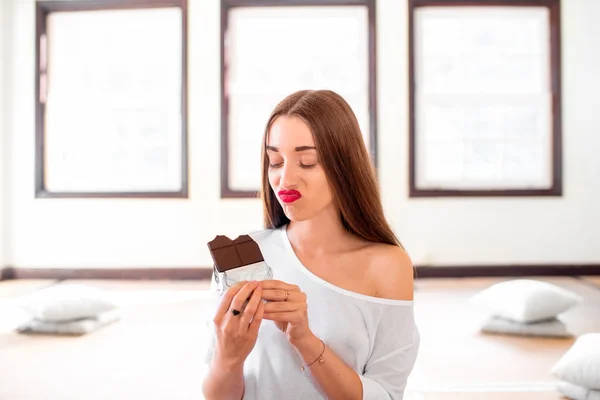 Woman with disappointed emotions holding chocolate