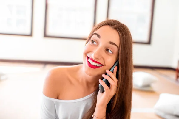 Žena s telefonem v tělocvičně — Stock fotografie