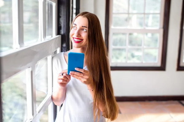 Telefonunuzun ve spor salonunda kadın — Stok fotoğraf