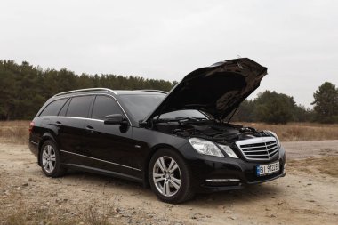 Dnipro, Ukrayna - 21 Kasım 2020: Mercedes-Benz E220 CDI 2011 sonbahar şehrinde orman yakınlarındaki siyah renk