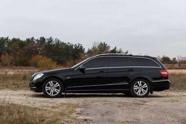 Dnipro, Ukrayna - 21 Kasım 2020: Mercedes-Benz E220 CDI 2011 sonbahar şehrinde orman yakınlarındaki siyah renk
