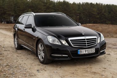 Dnipro, Ukrayna - 21 Kasım 2020: Mercedes-Benz E220 CDI 2011 sonbahar şehrinde orman yakınlarındaki siyah renk