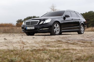 Dnipro, Ukrayna - 21 Kasım 2020: Mercedes-Benz E220 CDI 2011 sonbahar şehrinde orman yakınlarındaki siyah renk